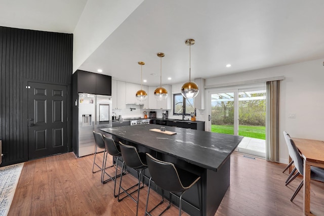 1324 Elmhurst Ln, Schaumburg, IL 60194 - kitchen with stainless steel fridge, a breakfast bar area, light wood-style flooring, a center island, and hanging light fixtures