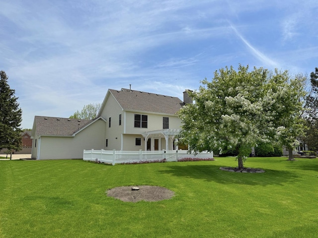 rear view of house featuring a pergola, a lawn, a chimney, and roof with shingles