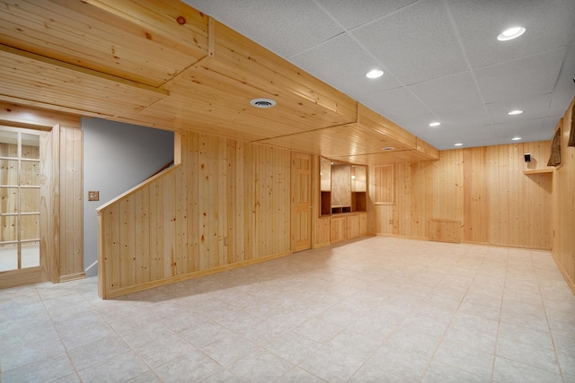 finished below grade area featuring wood walls, light floors, and recessed lighting