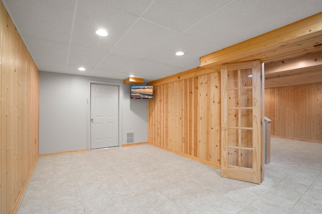 finished basement featuring wooden walls, baseboards, and recessed lighting