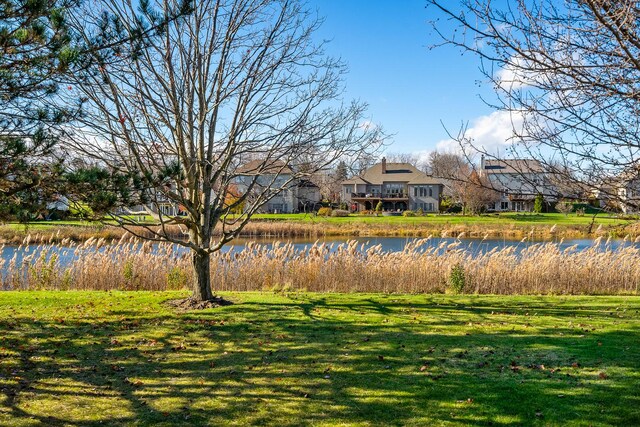 view of property's community with a water view and a yard