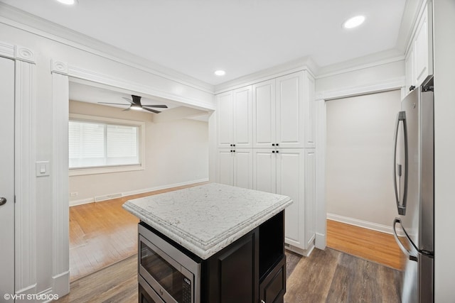 walk in closet featuring dark wood finished floors and a ceiling fan