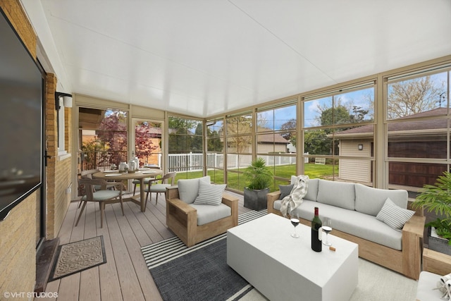 sunroom featuring an outdoor hangout area, plenty of natural light, and outdoor dining space