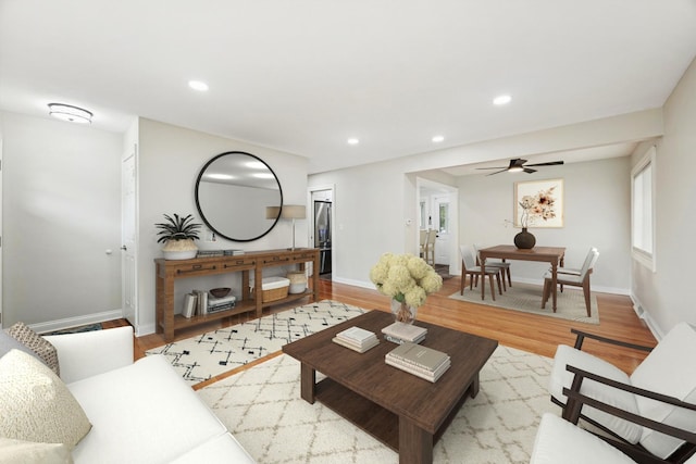 living room with light wood-type flooring, baseboards, a ceiling fan, and recessed lighting