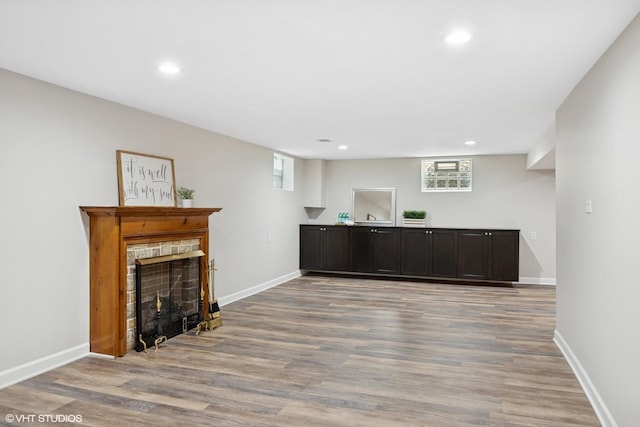 bar featuring light wood-style flooring, recessed lighting, a fireplace, and baseboards