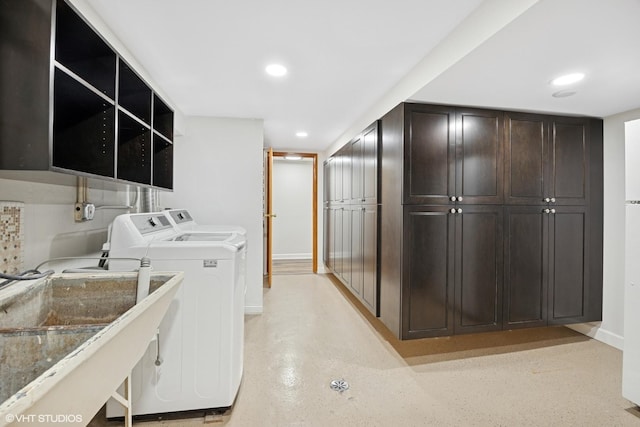 clothes washing area featuring washing machine and dryer, recessed lighting, baseboards, and a sink