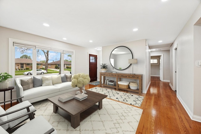 living area featuring plenty of natural light, baseboards, light wood-style floors, and recessed lighting