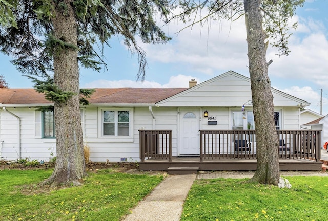 view of front of home featuring a deck, a chimney, a front yard, and roof with shingles