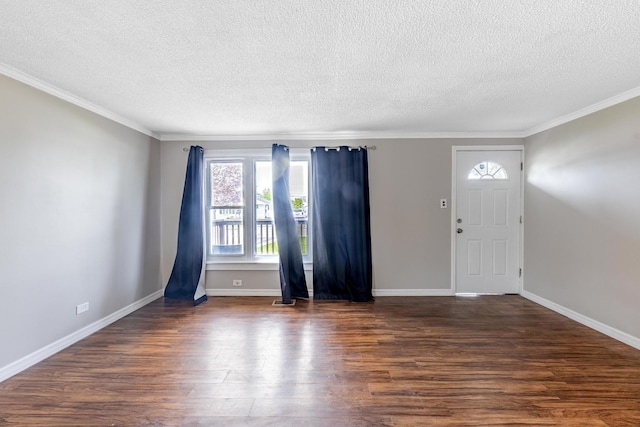 foyer entrance featuring wood finished floors, a textured ceiling, ornamental molding, and baseboards
