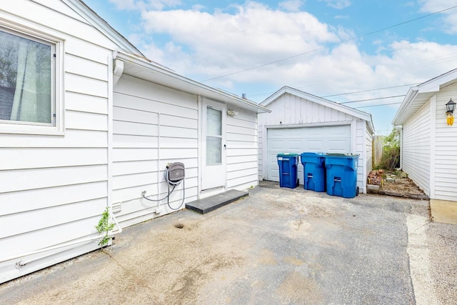 view of patio / terrace featuring a garage and an outbuilding
