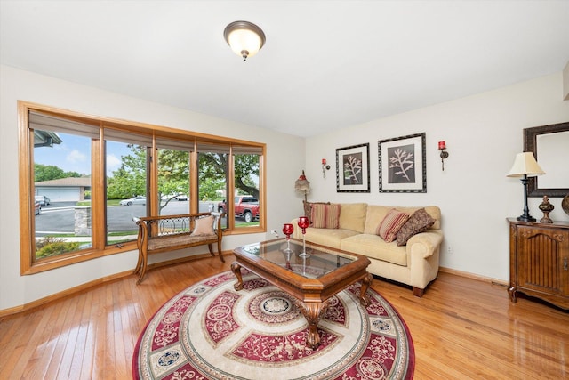 living area featuring healthy amount of natural light, light wood-style flooring, and baseboards