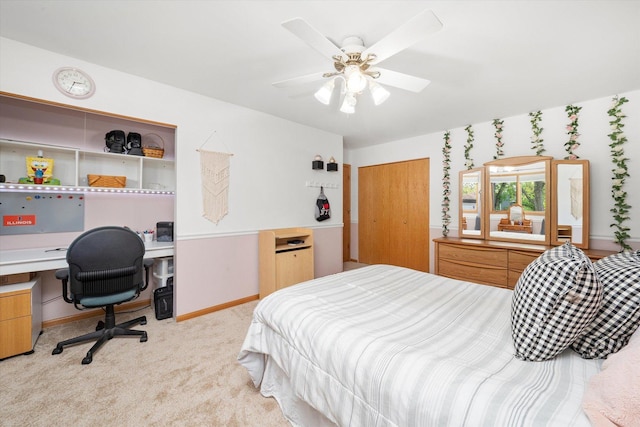 bedroom with light carpet, a desk, baseboards, and a ceiling fan