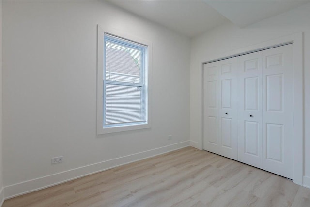 1808 N Karlov Ave, Chicago, IL 60639 - unfurnished bedroom with light wood-type flooring, baseboards, and a closet