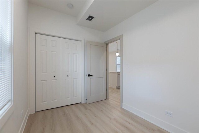 1808 N Karlov Ave, Chicago, IL 60639 - unfurnished bedroom with light wood-type flooring, baseboards, and a closet