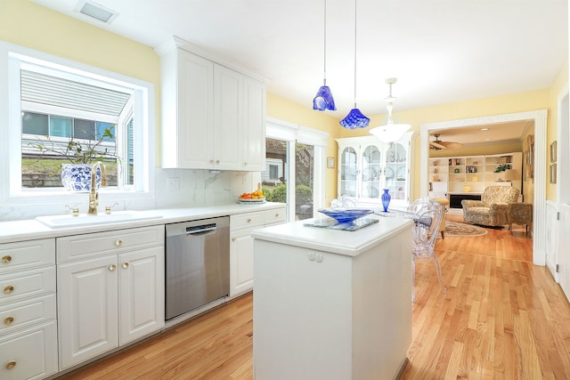 1054 Evergreen Dr, Carol Stream, IL 60188 - kitchen with stainless steel dishwasher, a sink, light wood-style flooring, a kitchen island, and white cabinetry