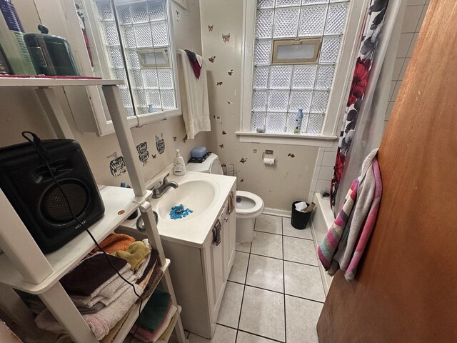 full bath with tile patterned flooring, toilet, vanity, and shower / bath combo