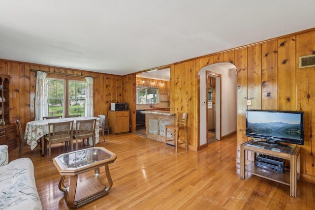 26211 W Spring Grove Rd, Antioch, IL 60002 - living room featuring wooden walls, arched walkways, and light wood-style floors