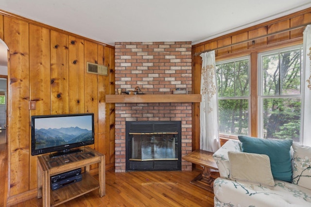26211 W Spring Grove Rd, Antioch, IL 60002 - living area with wood finished floors, wood walls, a fireplace, and arched walkways