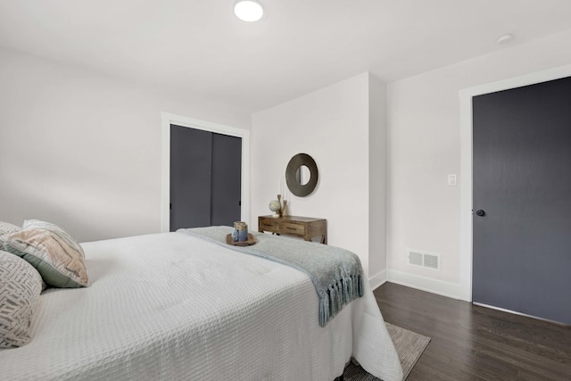 bedroom featuring wood finished floors, baseboards, and a closet