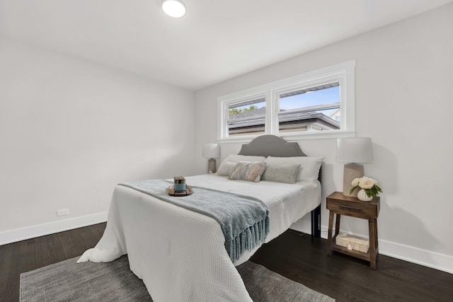 bedroom with baseboards and dark wood-type flooring