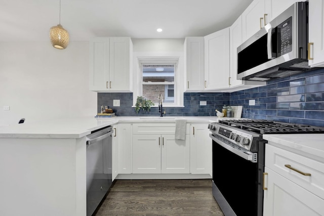 kitchen featuring appliances with stainless steel finishes, a sink, dark wood-style flooring, decorative backsplash, and recessed lighting