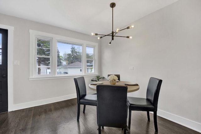 dining room featuring healthy amount of natural light, a chandelier, baseboards, and dark wood finished floors