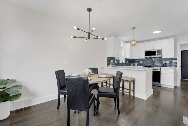 dining area with a chandelier, dark wood-style floors, baseboards, and recessed lighting