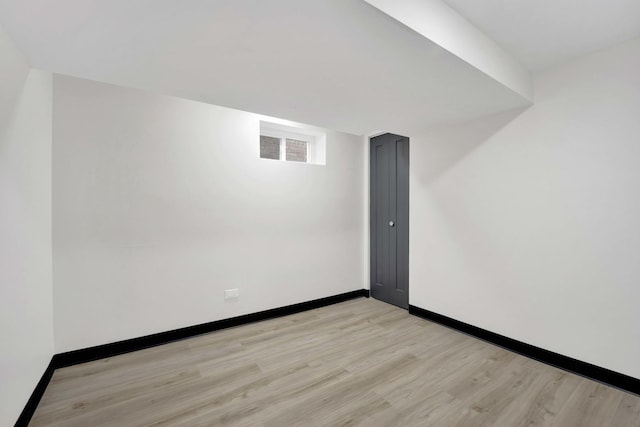 spare room featuring light wood-type flooring and baseboards