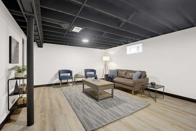 living area with baseboards and wood finished floors