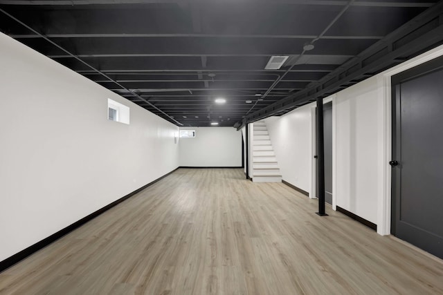 below grade area with wood finished floors, baseboards, and stairs