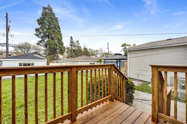 wooden terrace featuring a lawn and a gazebo