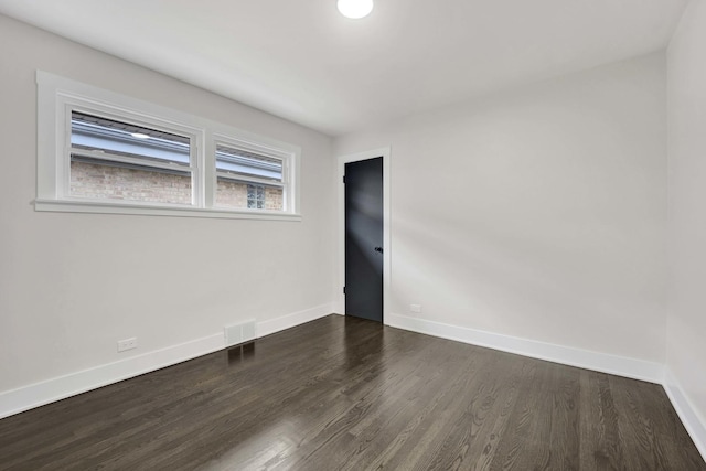 empty room with dark wood-style floors and baseboards