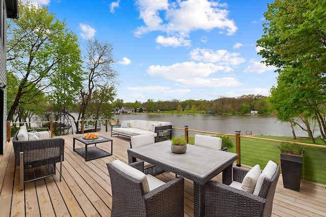 deck featuring a water view and an outdoor living space with a fire pit