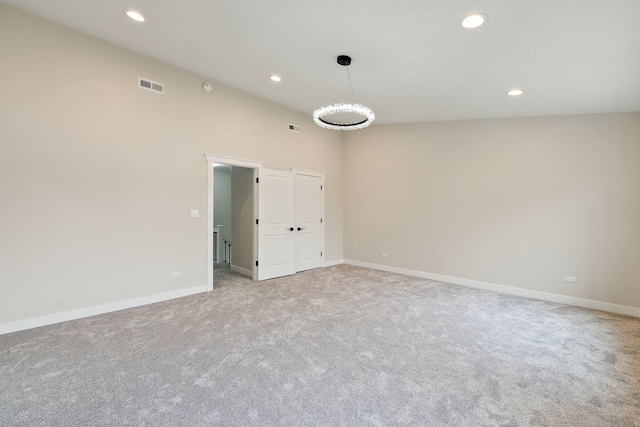 empty room featuring light carpet, recessed lighting, and baseboards