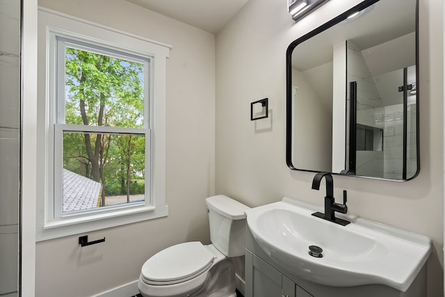 bathroom with toilet, vanity, and a stall shower
