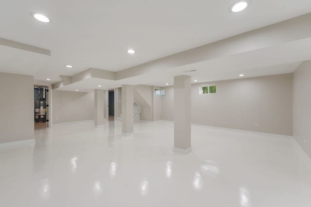 below grade area featuring stairs, recessed lighting, baseboards, and water heater