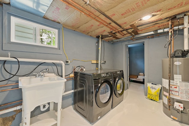 laundry room with gas water heater and washing machine and dryer