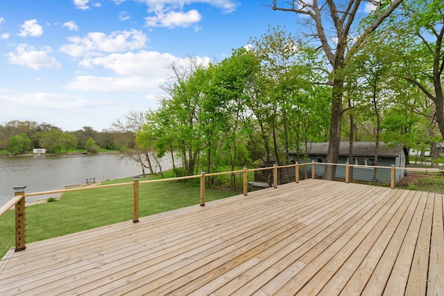 deck with a water view, a lawn, and view of wooded area