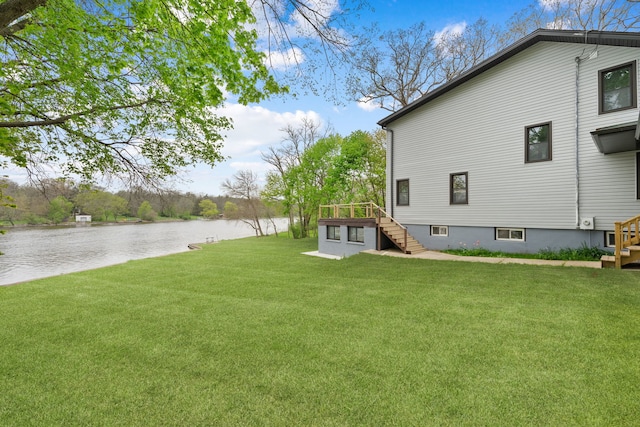 view of green lawn with stairway and a deck with water view
