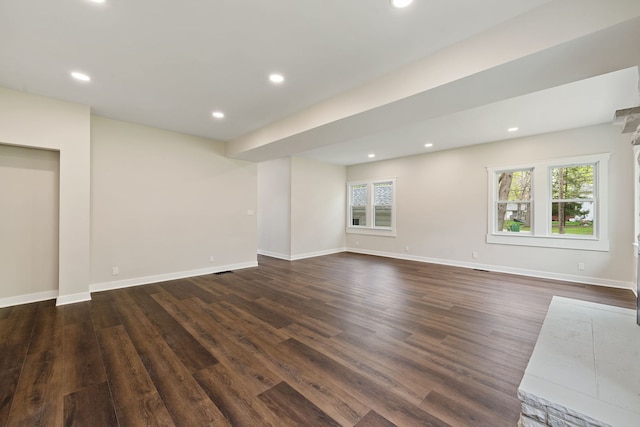 unfurnished living room featuring dark wood finished floors, recessed lighting, and baseboards