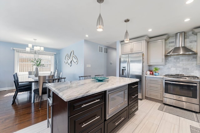 8557 W Winona St, Chicago, IL 60656 - kitchen featuring appliances with stainless steel finishes, wall chimney range hood, decorative backsplash, hanging light fixtures, and recessed lighting