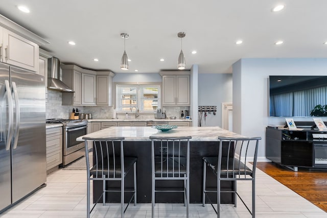 8557 W Winona St, Chicago, IL 60656 - kitchen with appliances with stainless steel finishes, wall chimney exhaust hood, gray cabinetry, a sink, and decorative backsplash
