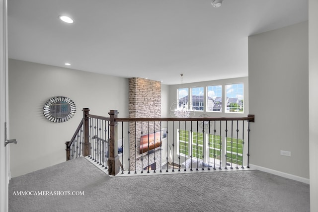 hallway with an upstairs landing, carpet flooring, baseboards, and recessed lighting