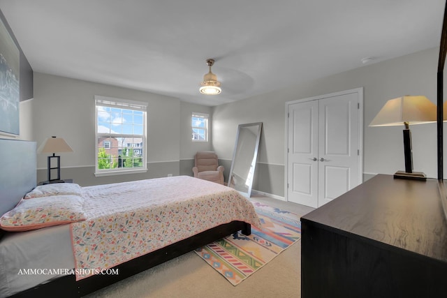 bedroom with carpet flooring, a closet, ceiling fan, and baseboards