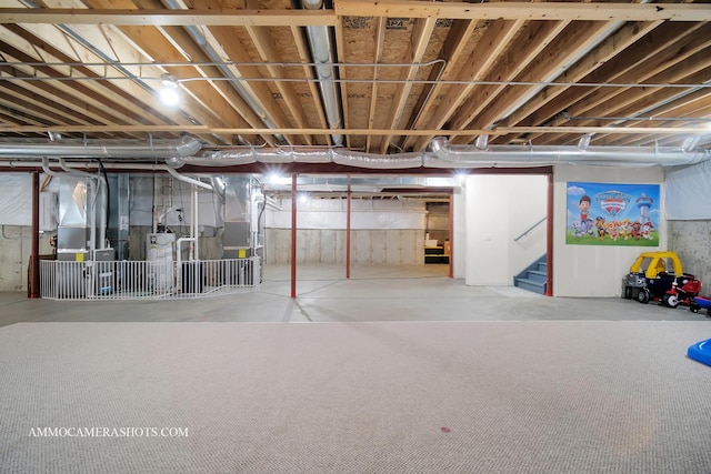 below grade area featuring stairs, heating unit, and water heater