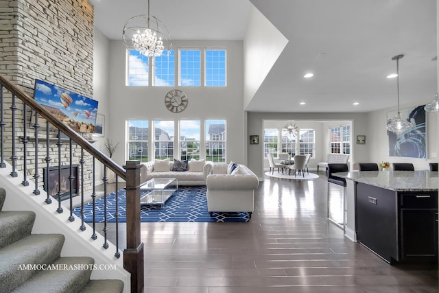 living room featuring a chandelier, stairway, dark wood-type flooring, and recessed lighting