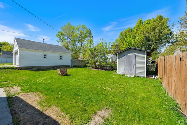 view of yard featuring an outbuilding, an outdoor fire pit, and a shed