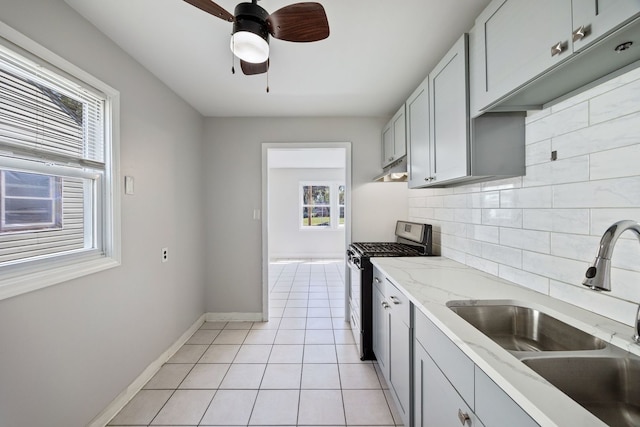 kitchen with stainless steel gas range, a sink, plenty of natural light, and decorative backsplash