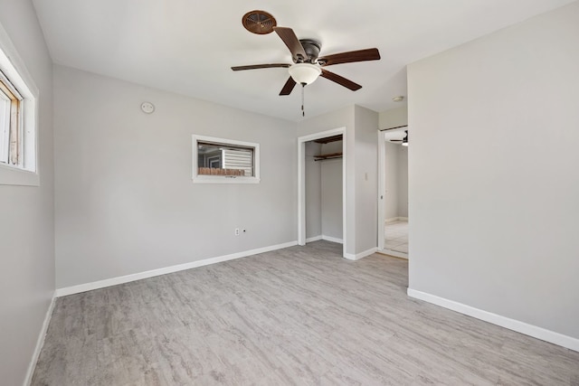 unfurnished bedroom with a closet, baseboards, wood finished floors, and a ceiling fan