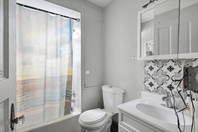 full bathroom featuring toilet, shower / bath combo with shower curtain, and vanity